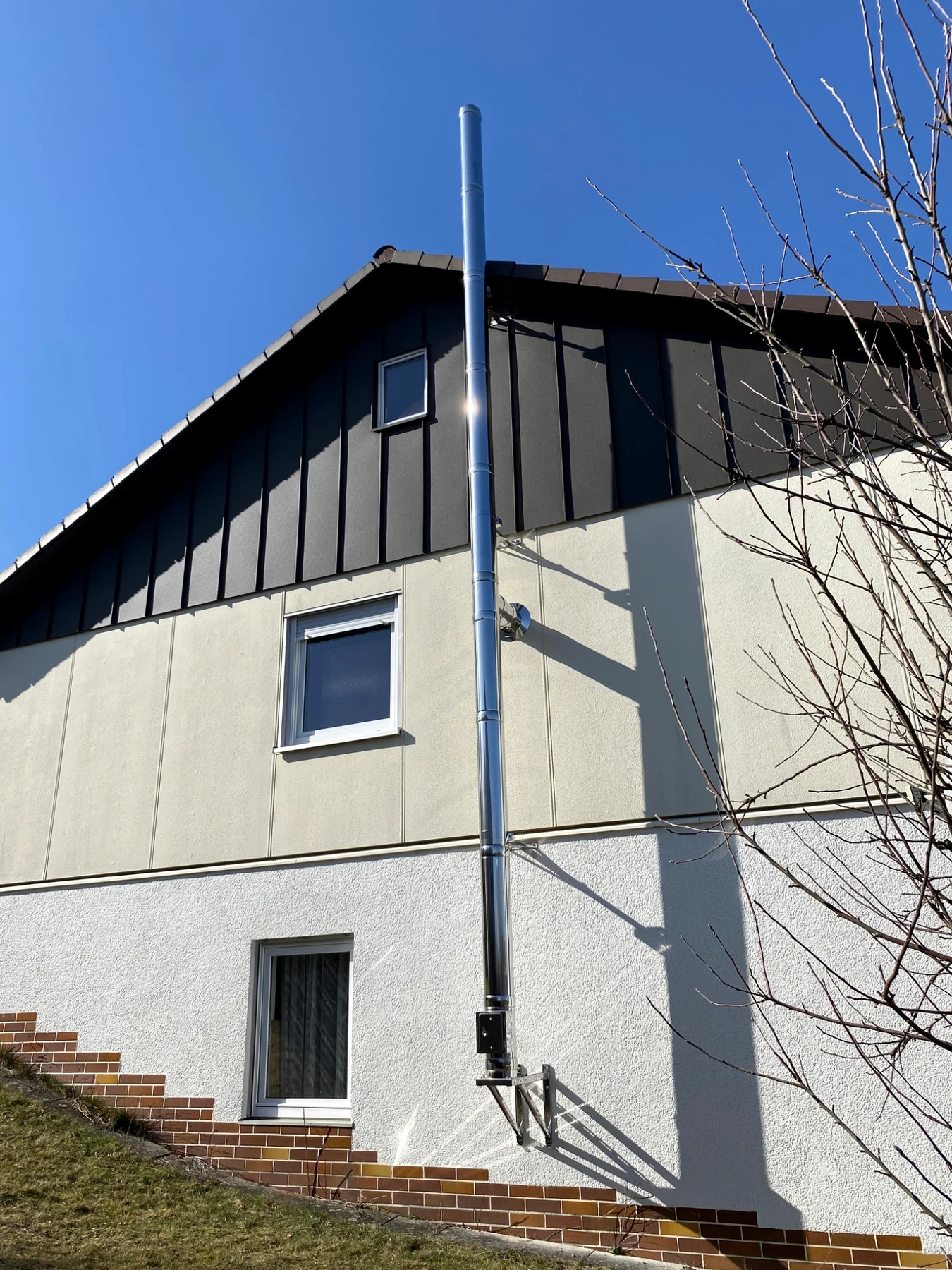 Detailansicht von Wandkonsole und Reinigungsbereich des Edelstahl-Außenwandkamins