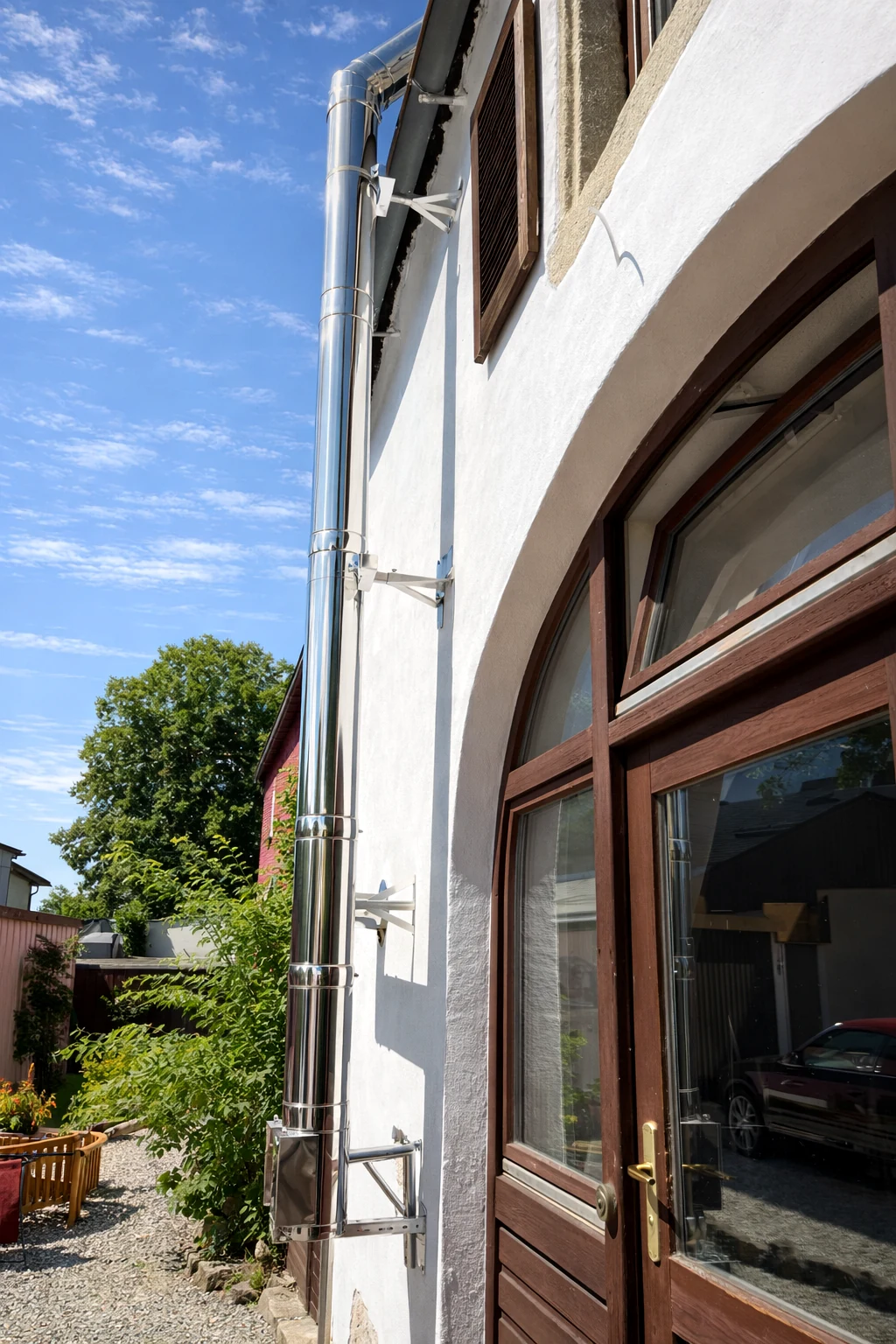 Seitliche Ansicht des doppelwandigen Edelstahl-Außenkamins an einem Wohnhaus im Landkreis Hof
