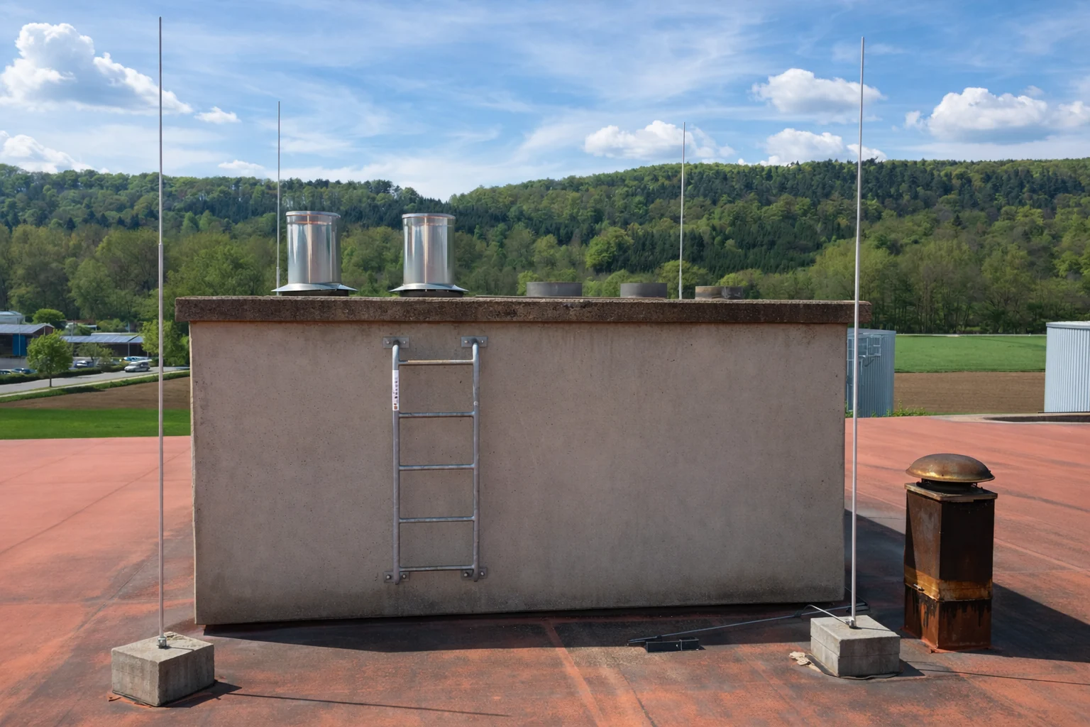 Zwei Edelstahlmündungen der Abgasanlage eines Jenbacher-Blockheizkraftwerks auf dem Dach