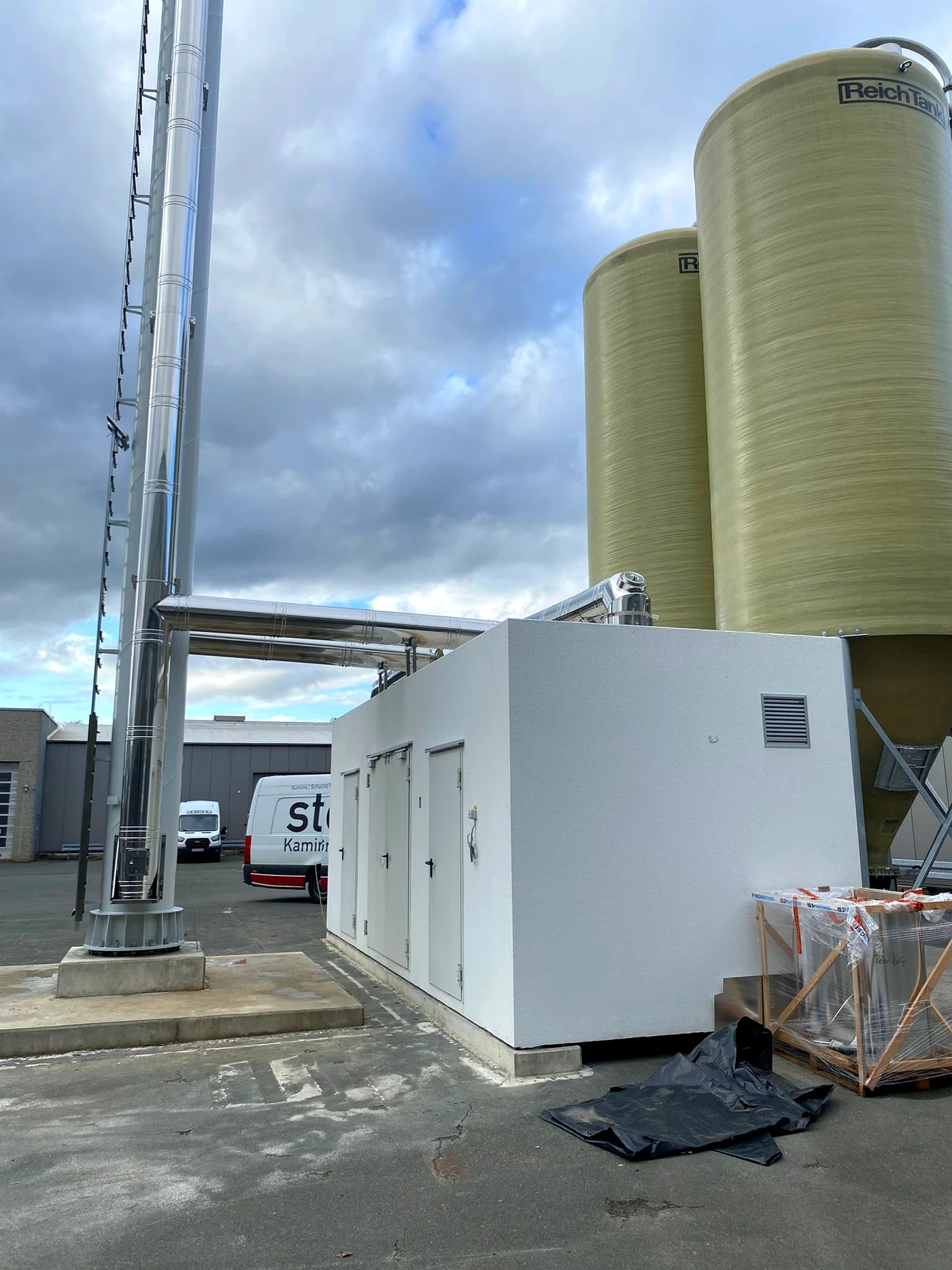 Gesamtansicht der Kaminanlage mit Energiebox und Silos am Produktionsstandort in Michelau